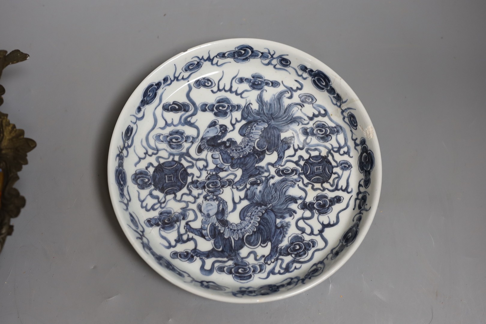 A Chinese clobbered dish with bronze mount, a Chinese blue-and-white Buddhist lion dish and a blue and white landscape bowl, 18th century and later